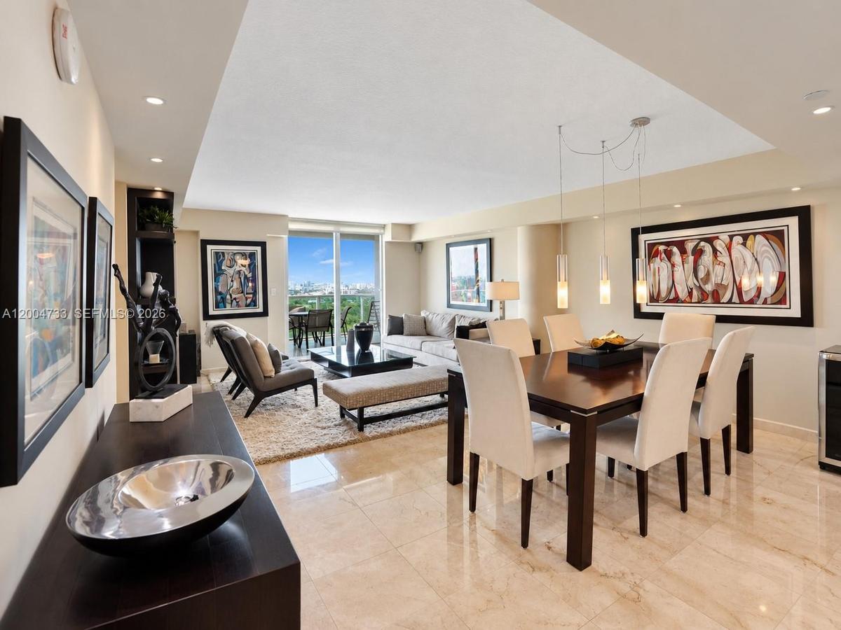 Open-concept living and dining area featuring polished stone tile flooring, recessed ceiling lighting, a dedicated multi-pendant light fixture, and fl