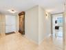 Entryway featuring polished stone tile flooring, a wall-mounted decorative stone-finish water feature, and rectangular flush-mount lighting fixtures