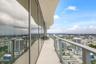 Expansive wrap-around balcony featuring full-height glass walls, curved architectural soffit, and sleek metal railing
