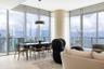 Floor-to-ceiling glass walls, wrap-around balcony with glass railing, large-format tile flooring, cylindrical structural column, and modern matte blac