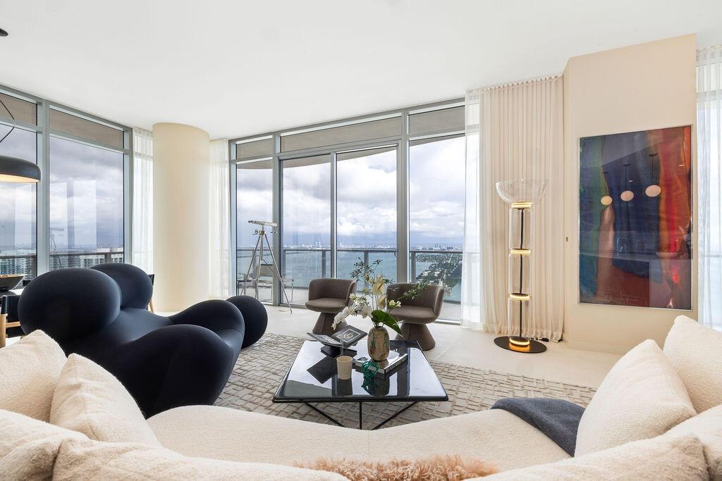 Floor-to-ceiling windows featuring panoramic water scenery, wraparound glass balcony, and smooth-finish flooring