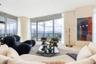 Floor-to-ceiling windows featuring panoramic water scenery, wraparound glass balcony, and smooth-finish flooring