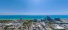 Aerial perspective showcasing a coastal cityscape with direct ocean frontage and expansive horizon