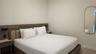 Integrated wood-finish headboard with built-in side tables, low-profile bed platform, and oval wall-mounted mirror