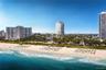 Coastal beachfront location featuring an expansive shoreline, natural dunes, and mature tropical landscaping