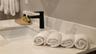 Bathroom vanity featuring a light-toned countertop with integrated backsplash, rectangular undermount sink, and matte black single-handle faucet