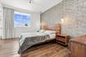 Textured accent wall, wood-finish flooring, and dual glass pendant light fixtures
