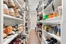 Custom floor-to-ceiling shelving with modular storage, built-in recessed ceiling lighting, and wide-plank wood-finish flooring