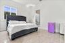 Neutral-toned polished tile flooring and recessed ceiling lighting within a bright, minimalist room featuring a large sliding window