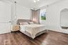 Wood-finish flooring, matte gold-tone pendant lighting, and a neutral color palette