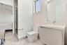 Floating vanity with stone countertop, integrated basin, glass-enclosed shower, stone-finish flooring, and recessed lighting