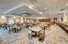 Large open-concept space featuring a multi-tiered tray ceiling, recessed lighting, integrated square light fixtures, patterned wall-to-wall carpeting,