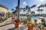 Outdoor swimming pool with paver decking, surrounding palm trees, and covered pavilion