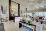 Expansive lobby featuring a stone-faced reception desk, floor-to-ceiling decorative wall mirror, high ceilings with globe chandeliers, and a glass-pan