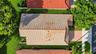 Aerial perspective of a residence featuring a clay tile roof, a paved driveway, and established landscaping