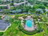 Community amenities featuring an outdoor swimming pool, spa, shaded pavilion areas, and a paved bocce ball court set within landscaped grounds