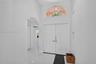 Double-door entryway featuring a high-reaching ceiling, arched transom window, and smooth-finish flooring