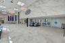 Spacious lobby featuring large-format stone-style tile flooring, decorative suspended ring lighting, and a prominent feature wall with marbled finish 
