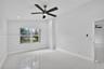 Room featuring polished tile flooring, a multi-blade ceiling fan with integrated lighting, recessed lighting, and a window with exterior scenery