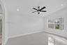 Interior room featuring vaulted ceilings, large-format tile flooring, a multi-blade ceiling fan with integrated light, and recessed lighting