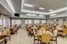 Expansive dining area featuring a tray ceiling with recessed lighting, integrated ceiling fans, ceramic tile flooring, and multiple windowed doors