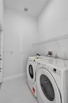 Laundry room featuring large-format tile flooring and a built-in wire shelving system