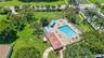 Community pool area featuring a paved deck, spa, and covered pavilion