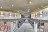 Auditorium space featuring a stage with proscenium arch, tiered fixed seating, acoustical wall paneling, recessed lighting, and patterned carpeting