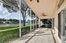 Screened-in lanai featuring tiled flooring, a vaulted ceiling, dual mounted ceiling fans, and a water-front location