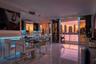 Large-format polished tile flooring, integrated linear LED under-cabinet lighting, stainless steel built-in appliances, and expansive sliding glass do