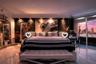 Polished stone flooring, floor-to-ceiling glass wall, and integrated recessed ceiling lighting