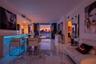 Open-concept living space featuring large-format polished stone-finish tile flooring, integrated linear LED accent lighting, and floor-to-ceiling slid