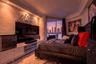 Custom built-in white cabinetry, recessed ceiling lighting, crown molding, polished stone flooring, and floor-to-ceiling glass sliding doors opening t