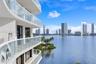 Multi-level exterior balcony featuring glass panel railings, concrete construction, and dark-framed sliding glass doors