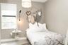 Ground floor bedroom, Neutral-toned interior space featuring a single-hung window, a decorative pendant light fixture, and a wall-mounted light fixtur