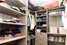 Walk-in closet system featuring custom wood-finish shelving, integrated clothing rods, and built-in drawer storage