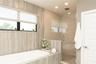 Master bath with frameless glass shower enclosure with pebble stone flooring, and recessed lighting