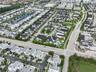 Aerial perspective of a suburban residential community featuring paved thoroughfares, organized residential lots with multi-level dwellings, and a cen