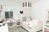 Polka-dot patterned accent wall, grey wood-finish flooring, and recessed ceiling lighting