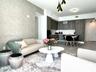 Open-concept living space featuring textured accent wallpaper, flat-panel dark wood-finish cabinetry, built-in stainless steel appliances, large-forma