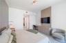 Custom floor-to-ceiling wood-finish wall paneling, integrated built-in cabinetry, streamlined desk workstation, and modern rectangular flush-mount cei