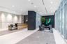 Lobby area featuring large-format tile flooring, stone-clad accent walls, floor-to-ceiling windows, recessed lighting, and a custom built-in reception