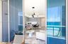 Full-height sliding glass doors opening to a covered balcony, integrated kitchen cabinetry, recessed ceiling lighting, pendant light fixture, and ocea