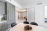 Modern kitchen cabinetry with wood-finish paneling, integrated refrigerator, white stone countertops, and tile flooring