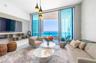 Floor-to-ceiling glass doors, custom built-in cabinetry, modern pendant lighting, textured wall finish, and a glass-paneled balcony