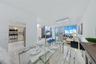 Open-concept interior featuring large-format tile flooring, recessed ceiling lighting, full-height windows, and integrated kitchen appliances