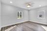 Neutral-toned room featuring wood-finish flooring, recessed lighting, and a ceiling fan with integrated light fixture