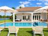Covered patio with a tile roof, rectangular swimming pool with an integrated spa, and limestone paver decking