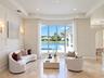 Formal living space featuring a bay window, wall molding, recessed ceiling lighting, wall-mounted light fixtures, and stone flooring