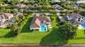 Expansive waterfront lot featuring a rectangular swimming pool, integrated spa, covered patio, and manicured lawn